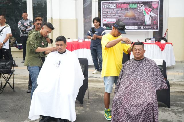 Wali Kota Medan, Bobby Nasution bersama dengan Dandim 0201/Medan Kolonel Inf Ferry Muzawwad memotong rambut di seputaran jalan Balai Kota atau tepatnya di depan Gedung Lonsum, Minggu (12/11/2023), sebagai bentuk dukungan kepada Palestina.