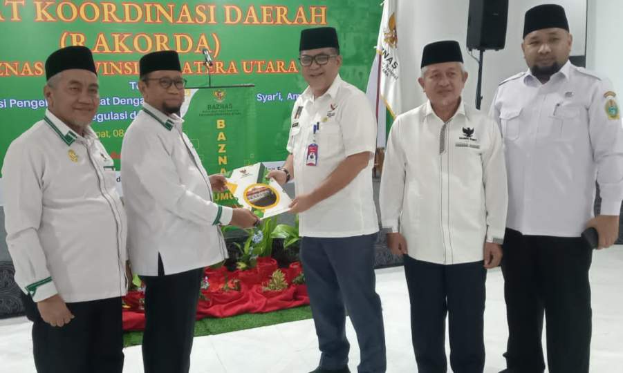 Kabiro Kesra Pemprovsu Muhammad Rahmadani Lubis SE MM saat menyerahkan bantuan yang diterima Ketua Baznas Sumut Prof Mohd Hatta.