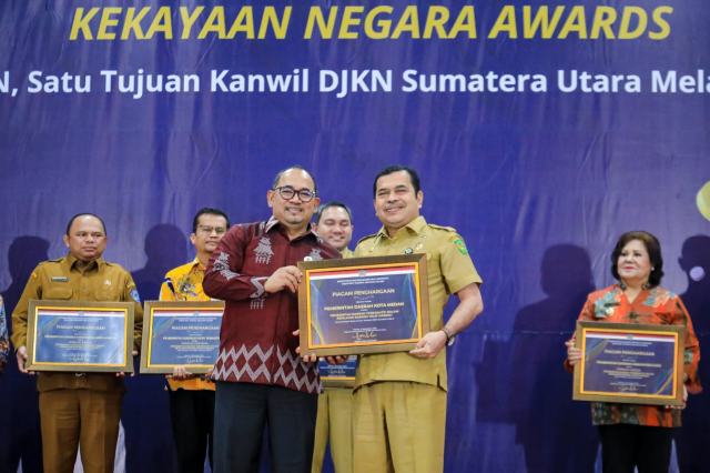 Wali Kota Medan Bobby Nasution diwakili Kaban BKAD Zulkarnain menerima penghargaan dari Kepala Kanwil DJKN Sumut, Dodok Dwi Handoko dalam ajang Kekayaan Negara (KN) Award di Aula Gedung Kekayaan Negara, jalan Diponegoro, Medan, Selasa (5/12/2023).