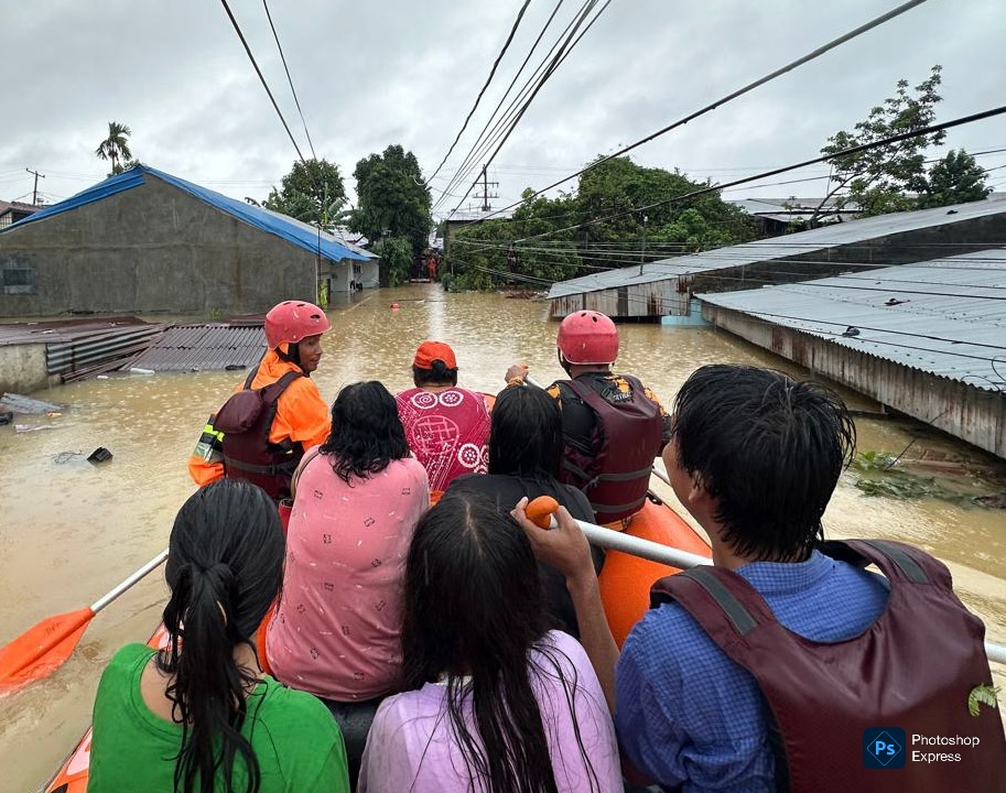Tim URC BPBD Medan tengah mengevakuasi warga saat banjir melanda Kota Medan beberapa waktu lalu. (Kominfo Medan Dok)